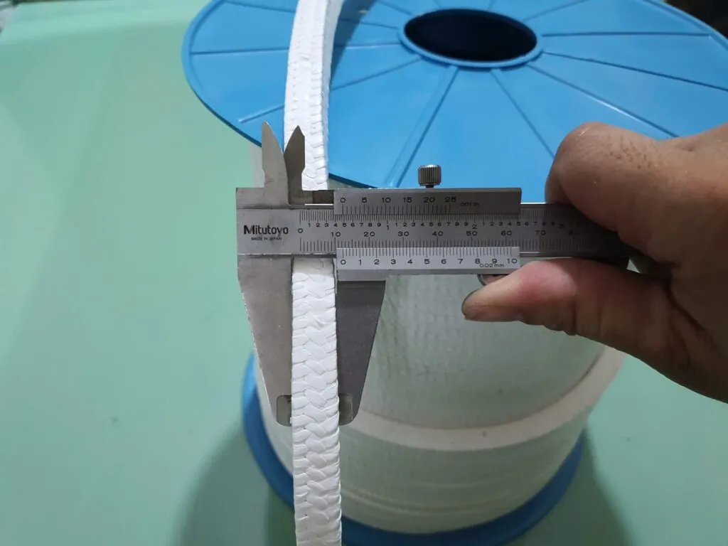 Cỡ dây tết chèn PTFE đo cạnh bằng thước kẹp trên cuộn lõi xanh