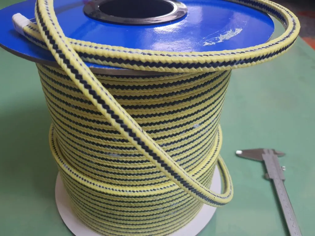 Dây tết chèn aramid carbon cuộn dựng trên lõi xanh, thước kẹp đặt cạnh