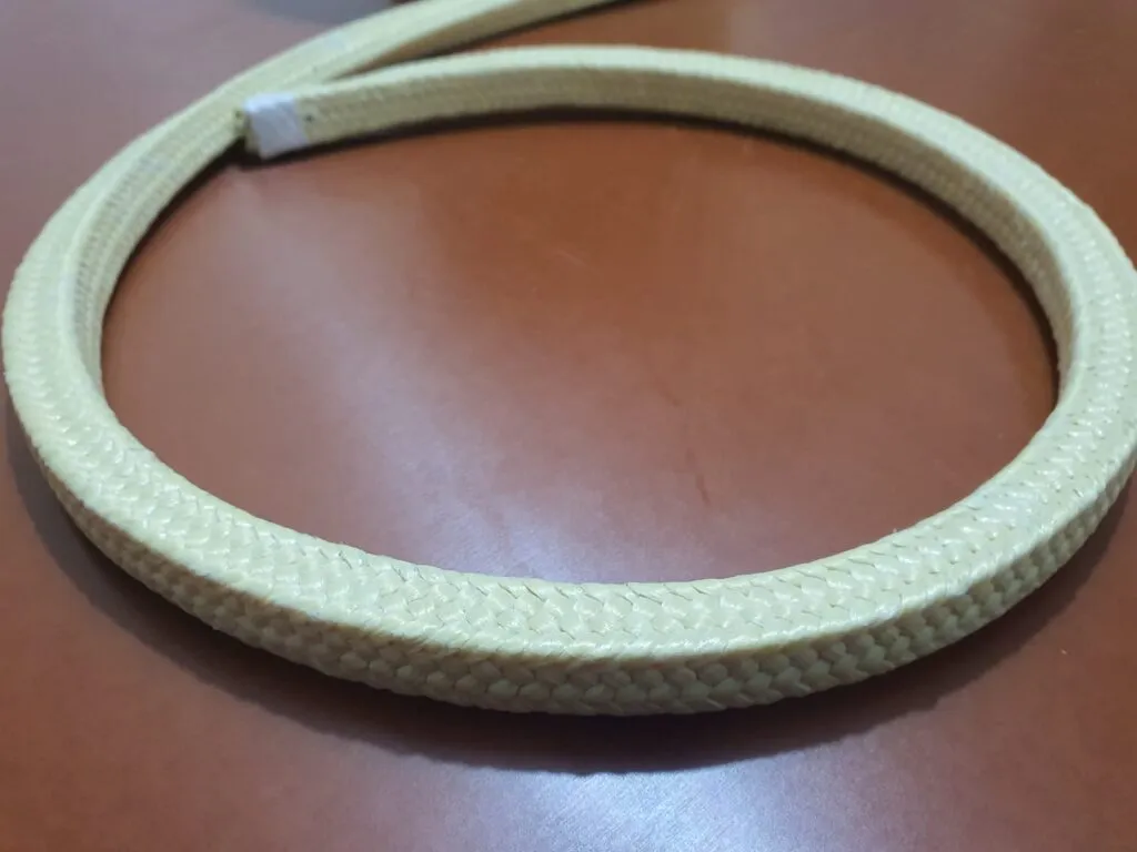 Dây tết chèn aramid một vòng dây vàng tròn đặt trên mặt bàn