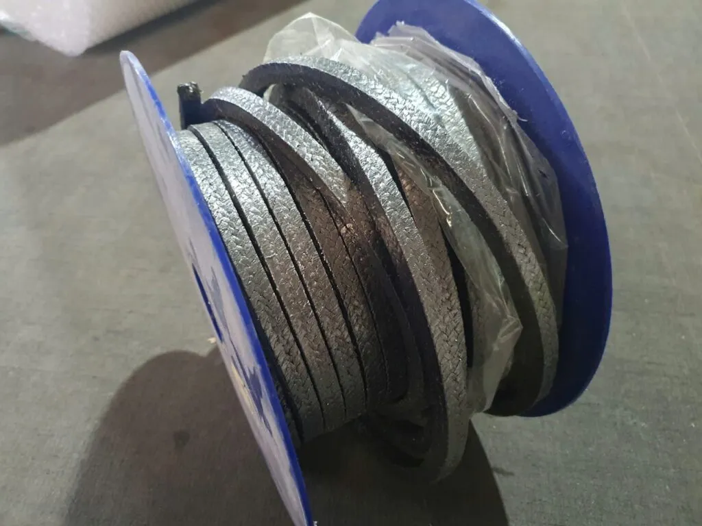 Dây tết chèn graphite cuộn nghiêng trên lõi xanh, đầu dây xổ ra ngoài