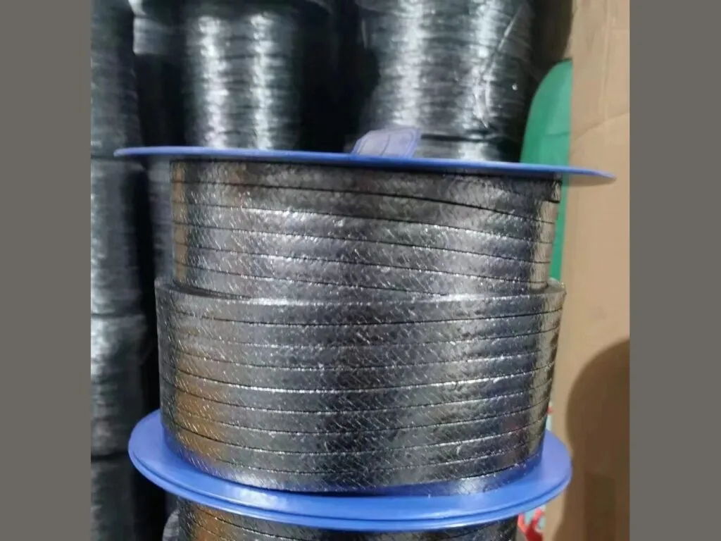 Dây tết chèn graphite lưới inox cuộn trên lõi xanh đặt giữa các cuộn khác