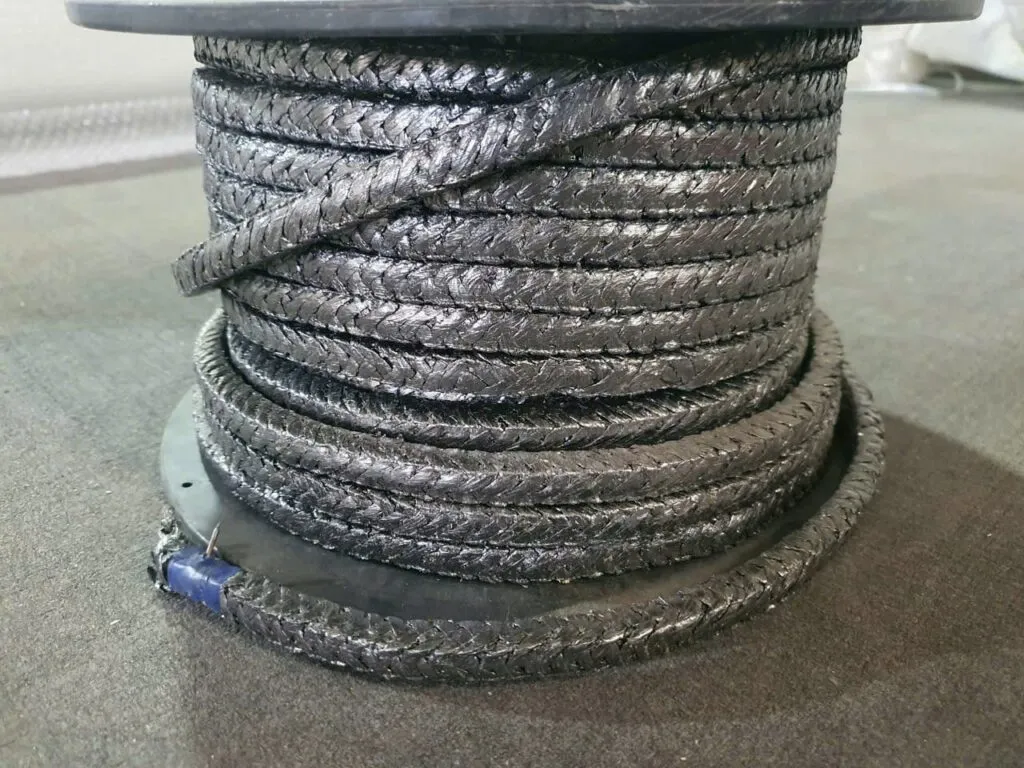 Dây tết chèn graphite màu bạc quấn nhiều tầng, vòng ngoài thả quanh đế cuộn
