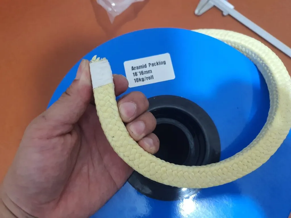 Dây tết chèn hay phớt cơ khí: dây aramid vàng uốn vòng trên tay cạnh lõi cuộn