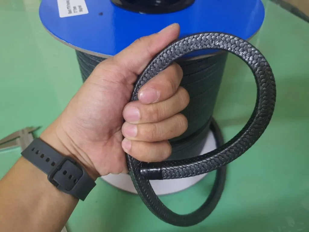 Dây tết chèn hay phớt cơ khí: vòng dây PTFE graphite cầm trên tay trước cuộn