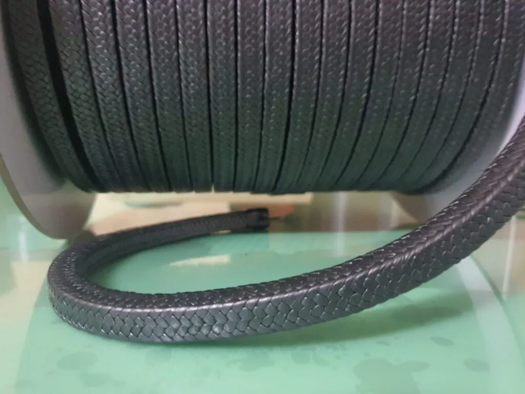Dây tết chèn ptfe graphite cuộn nằm ngang, đoạn dây đen thả ra phía trước