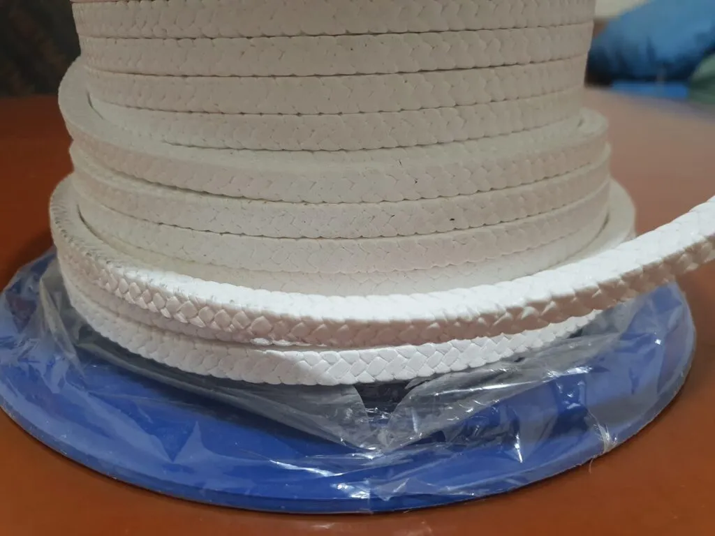 Dây tết chèn ptfe trắng quấn nhiều tầng trên lõi xanh, một vòng dây xổ ra quanh đế