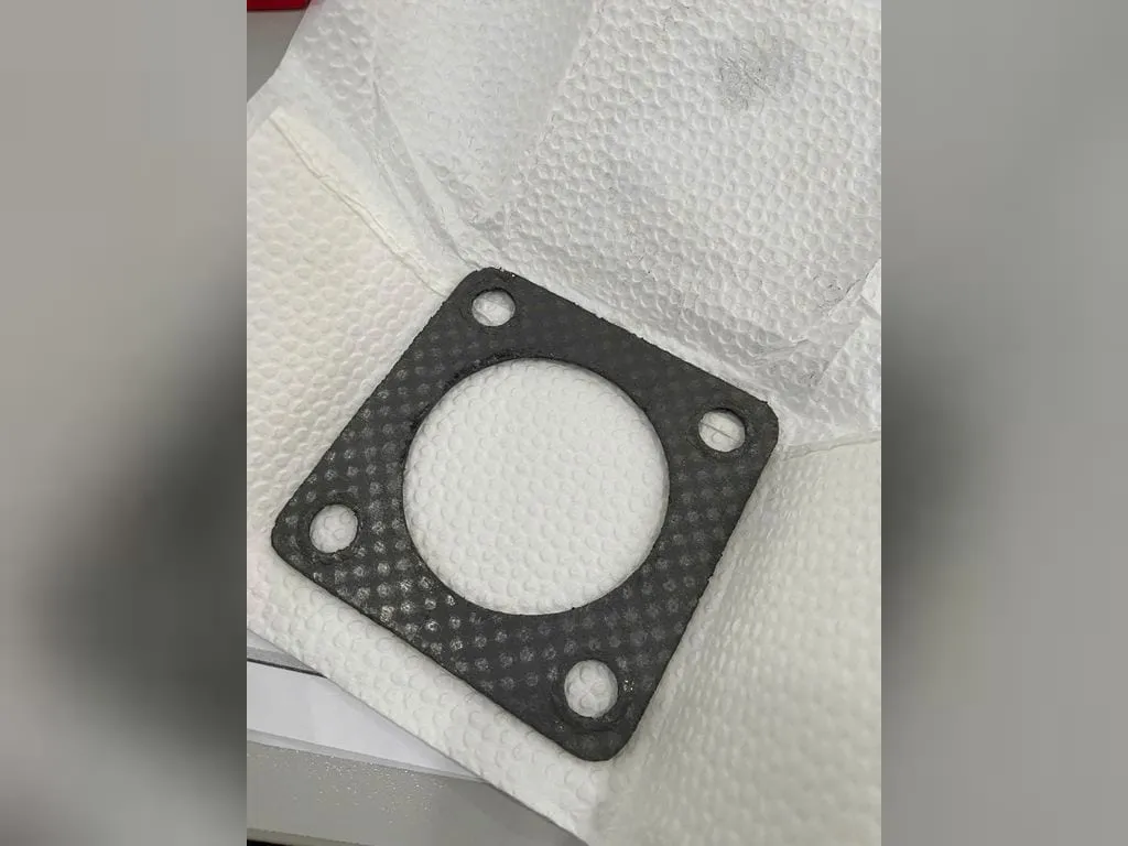 Gioăng chì graphite vuông bốn lỗ bu lông đặt trên khăn trắng