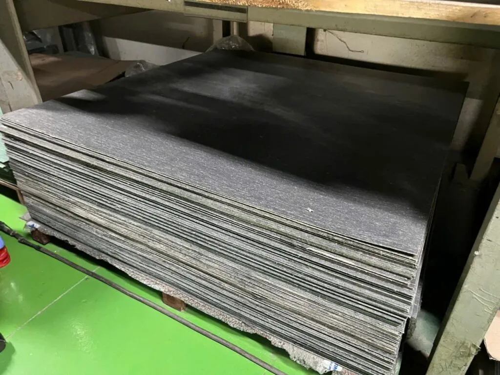 Gioăng không amiang: chồng tấm bìa xám trên pallet trong kho